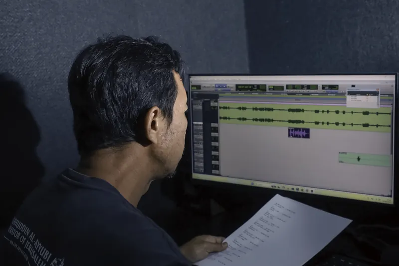 Audio engineer mixing and mastering a recording